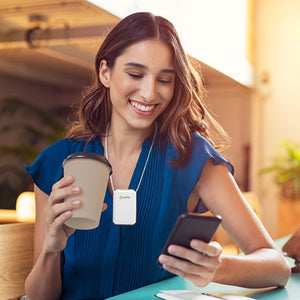 Woman drinking coffee wearing pureAir Solo personal air purifier
